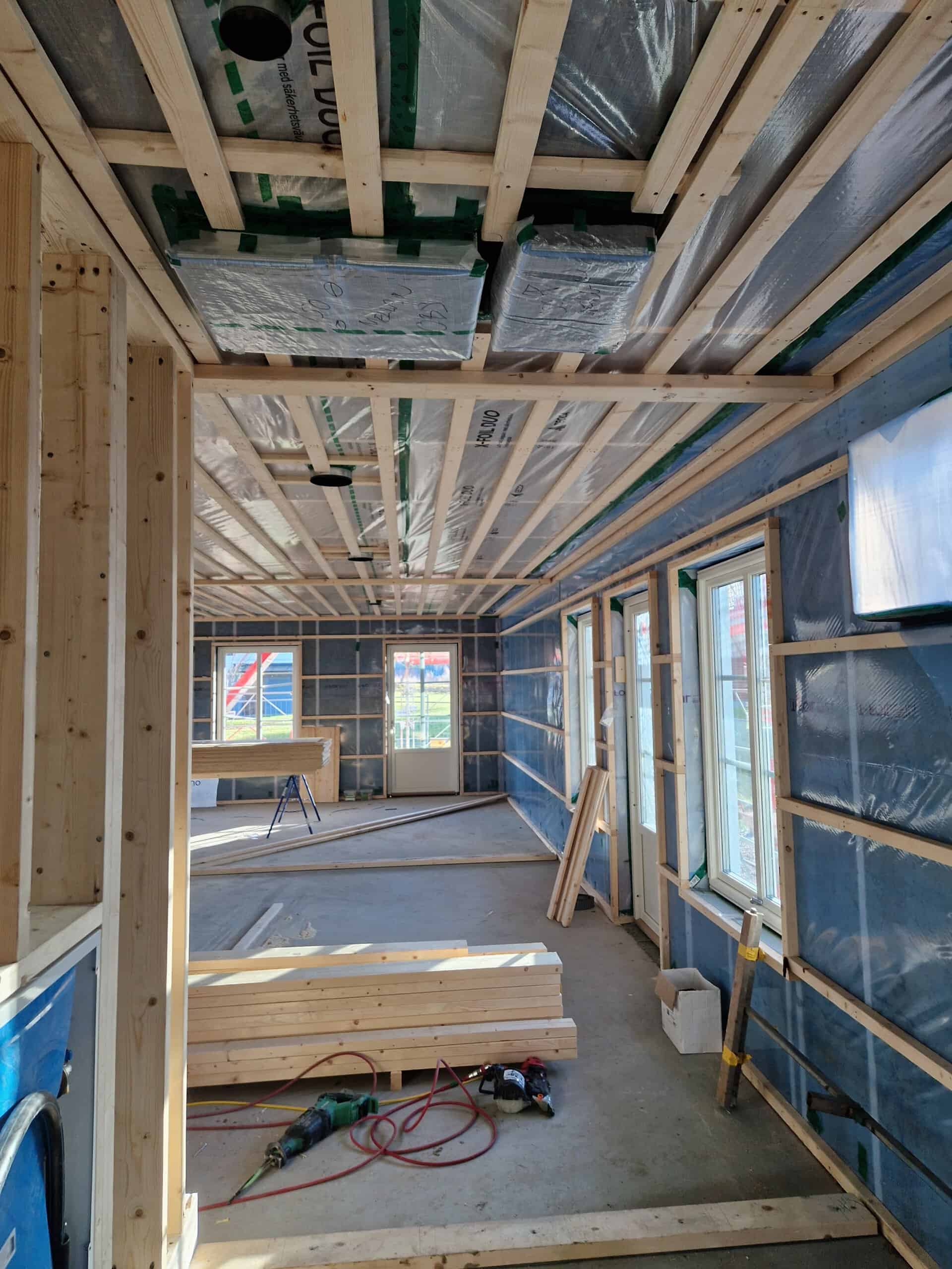 Inomhusbyggnation med trästommar och elinstallationer i pågående projekt.