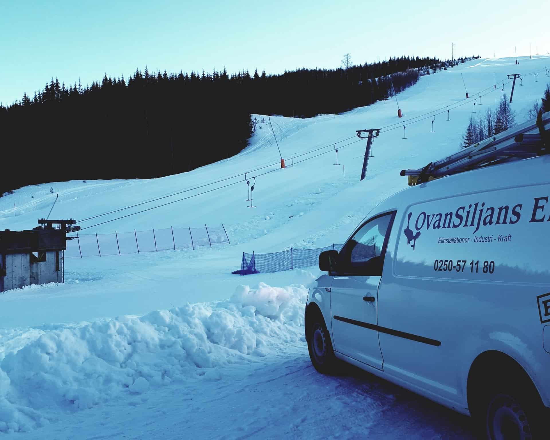 Snöskoter och lift vid Ovansiljans Elmän AB i snöigt landskap.